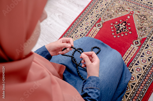 Fotografie Muslim woman prayer, muslim girl open hands praying with rug