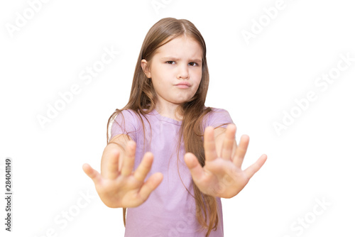 The little girl refuses and puts forward her hands. Isolated on a white background. photo