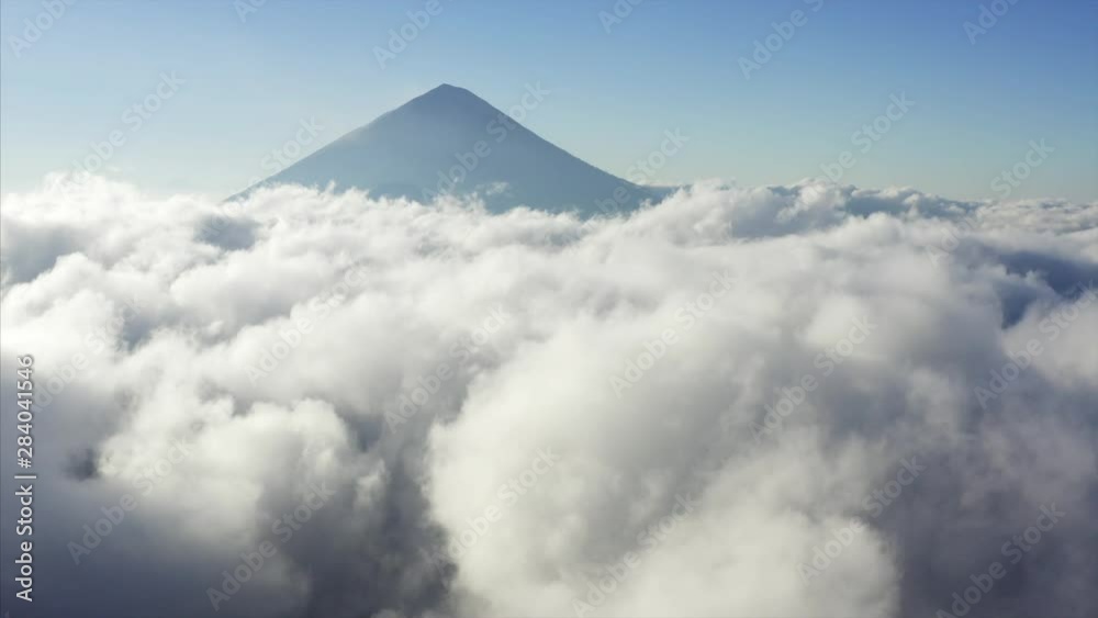 Flying above great white clouds in the morning. Aerial view of Agung mount, a currently active volcano in Bali, Indonesia and the highest point on Bali.