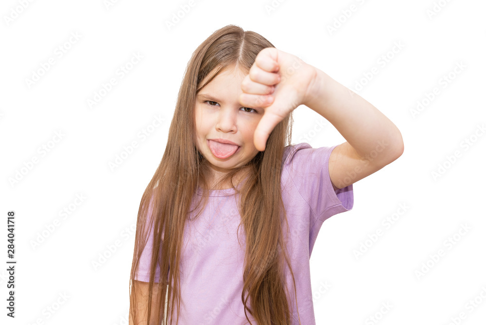A little girl shows a dislike sign, and makes a face. Isolated on a white background. A little girl shows a dislike sign, and makes a face. Isolated on a white background.