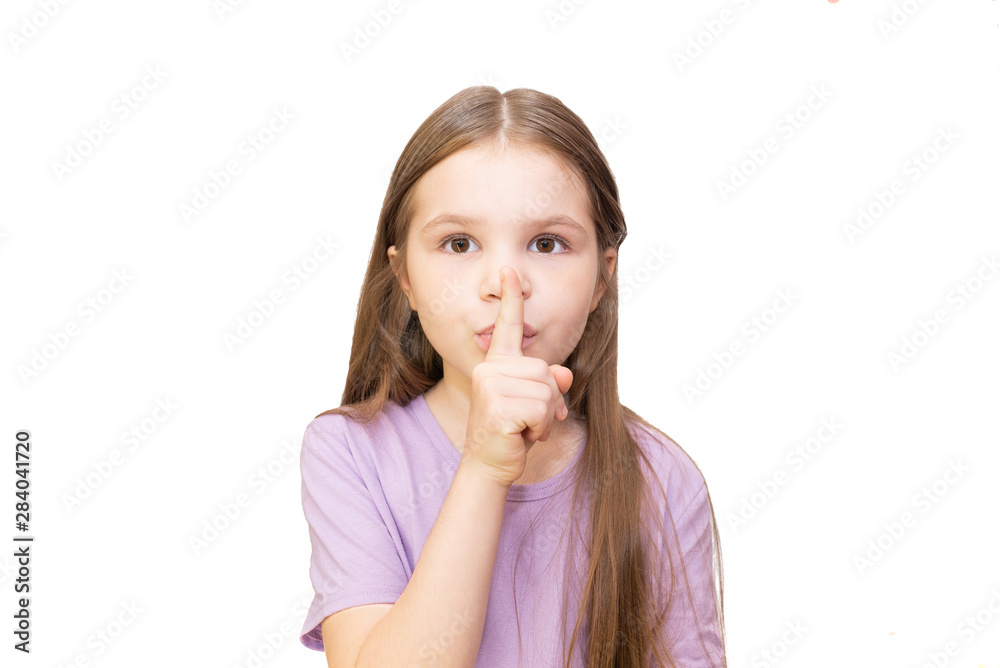 The little girl put her index finger to her mouth. Isolated on a white background. The little girl put her index finger to her mouth. Isolated on a white background.