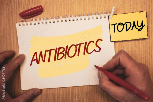 Text sign showing Antibiotics. Conceptual photo Drug used in treatment and prevention of bacterial infectionsMan creating for today on notebook Hand hold holding pen Wooden background photo