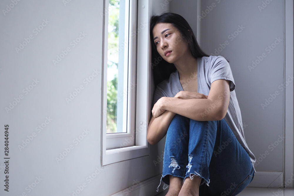 Asian girl sitting alone in the house. Depression concept