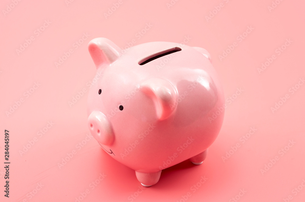 Prosperity in personal finances, money growth, modern economics and saving capital conceptual theme with a piggy bank isolated on pink background