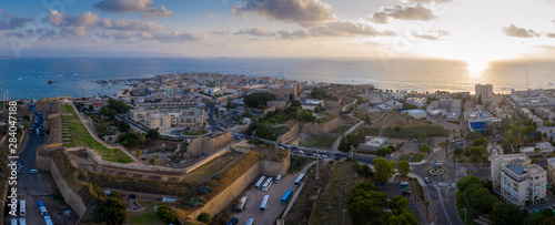 Aerial summer sunset view of Acco, Acre, Akko medieval old city with green roof Al Jazzar mosque and crusader palace, city walls, arab market, knights hall, crusader tunnels, in Israel