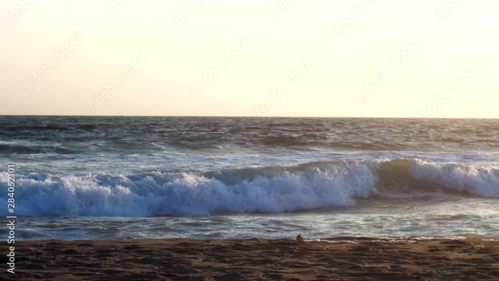 Slow motion waves crashing along shoreline at Venice Beach at sunset Slow motion waves crashing along shoreline at Venice Beach at sunset