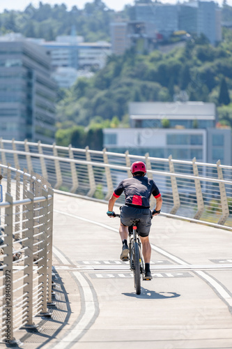Male enthusiast rides a bicycle on a bike path at Tilikum Crossing Bridge