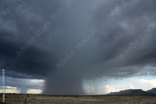 Local rain. Rain pours out of the clouds on the field