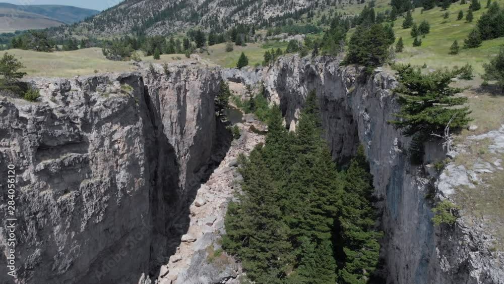 Rocky natural bridge falls dry creek caves in Montana on a sunny day, aerial shot Rocky natural bridge falls dry creek caves in Montana on a sunny day, aerial shot