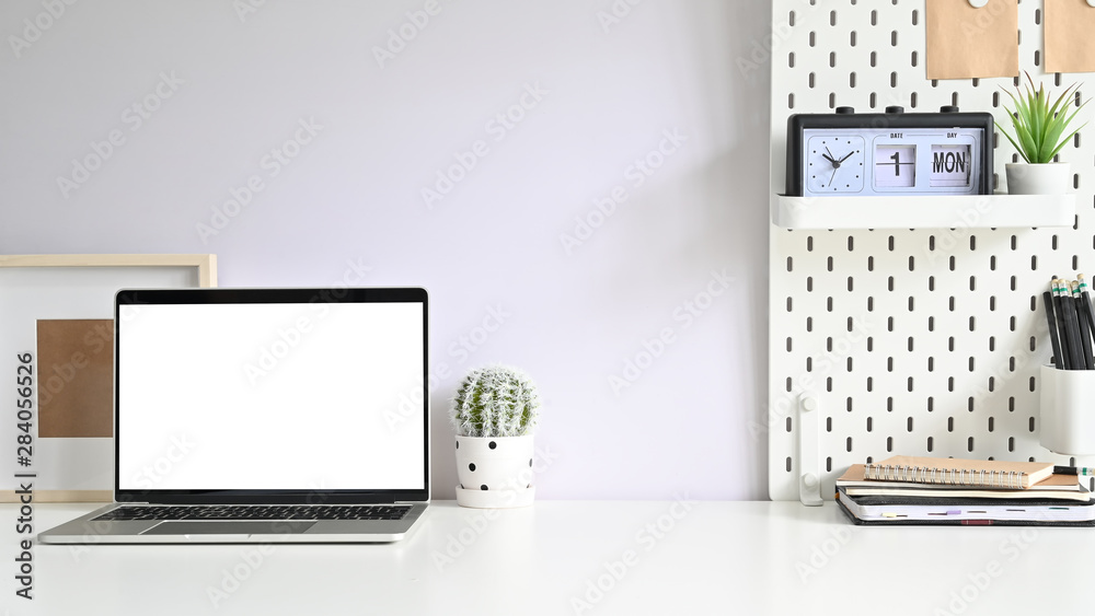 Obraz premium Workspace computer, Empty screen laptop and office supplies on white office desk.