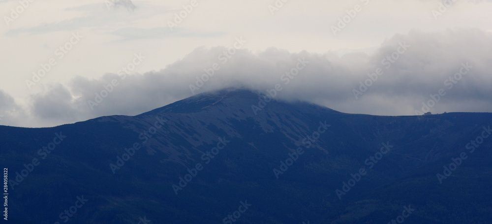 Sniezka Mountain in the clouds seen from Krzyzna Gora in Rudawy Janowickie
