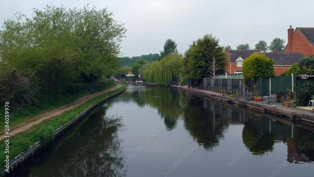 low fly over canal of Trent and Mersey next to beautiful suburban houses low fly over canal of Trent and Mersey next to beautiful suburban houses