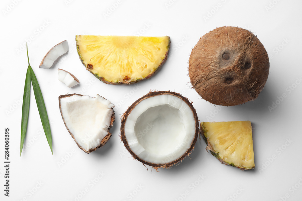 Composition with coconuts, juicy and leaves pineapple slices on white background, top view Composition with coconuts, juicy and leaves pineapple slices on white background, top view