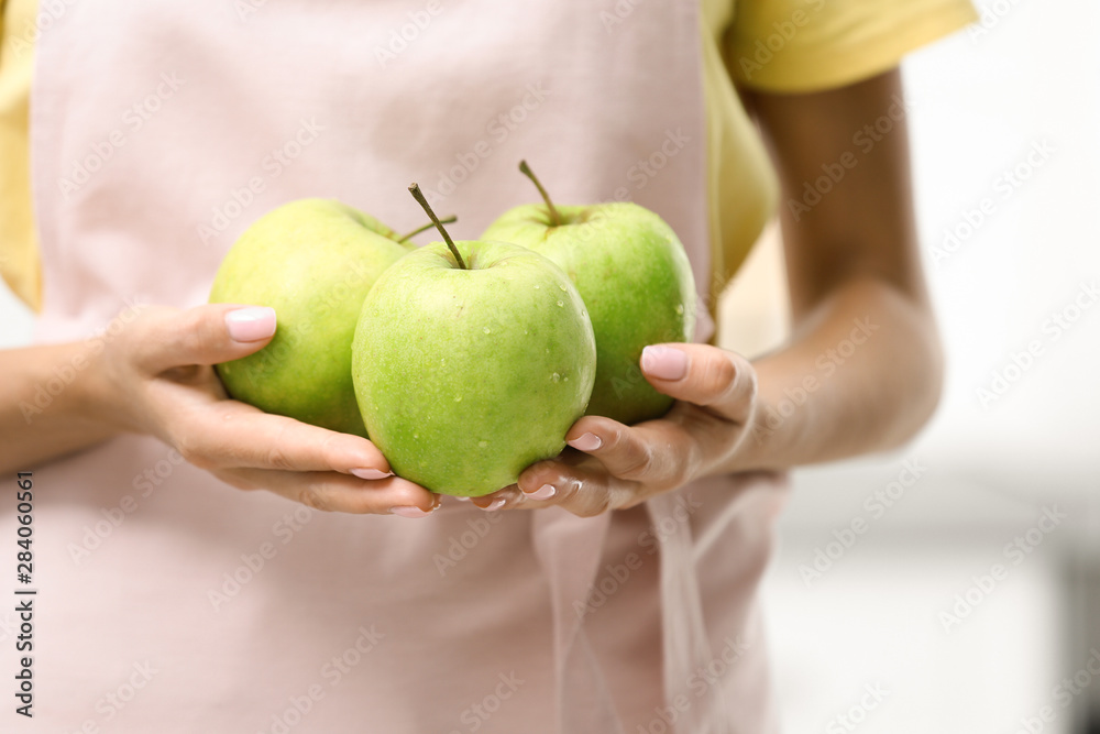 Woman holding ripe green apples indoors, closeup Woman holding ripe green apples indoors, closeup
