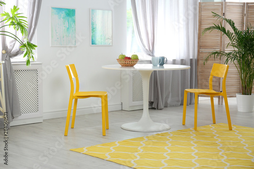 Room with comfortable table  chairs and stylish decor. Idea for interior design