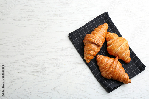 Tasty croissants and space for text on white wooden background, top view. French pastry