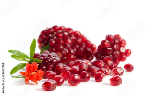 Parts of a pomegranate with pomegranate seeds and leaves, flowers isolated on white background