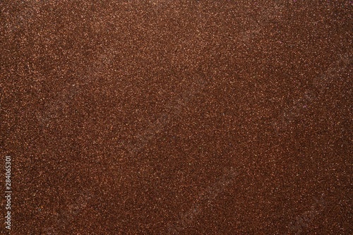 Brown glitter abstract shiny background. Design paper texture for decoration and design of Christmas, New Year or other holiday pictures. Beautiful packaging material.