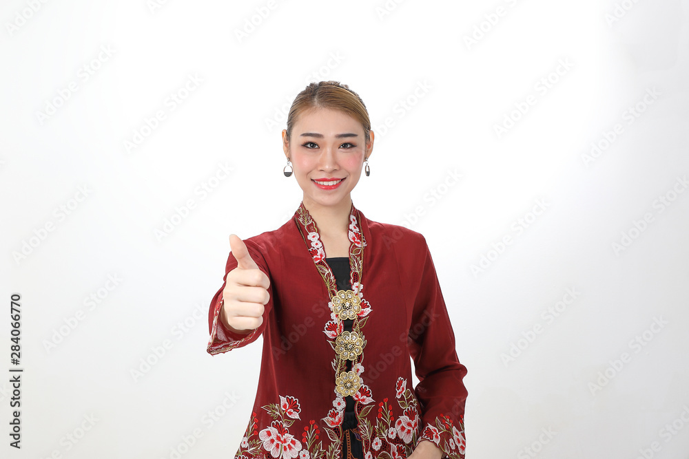 Asian woman traditional red maroon kebaya sharong on white background thumbs up ok focus on face Asian woman traditional red maroon kebaya sharong on white background thumbs up ok focus on face