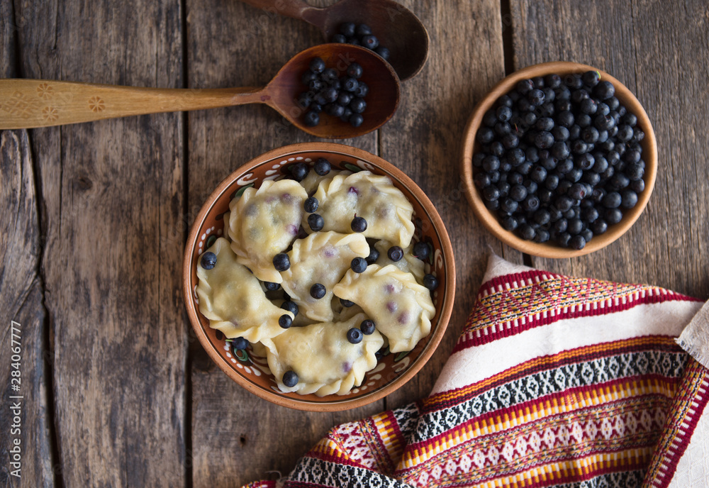 Preparing dumplings with blueberry. making pierogi or pyrohy, varenyky, vareniki. Traditional Russian cuisine, The traditional Ukrainian hand-made vareniki (dumpling) with blueberry inside Preparing dumplings with blueberry. making pierogi or pyrohy, varenyky, vareniki. Traditional Russian cuisine, The traditional Ukrainian hand-made vareniki (dumpling) with blueberry inside
