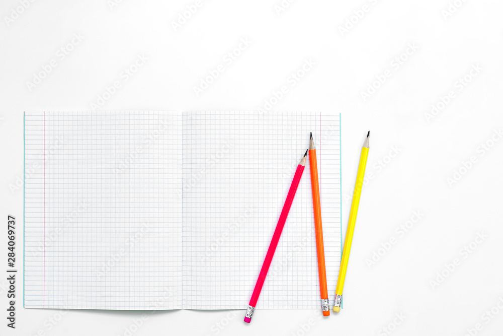 Blank notebook and pencils on white background. School supplies. White sketch book with colourful pencils. Note book and pencil Blank notebook and pencils on white background. School supplies. White sketch book with colourful pencils. Note book and pencil