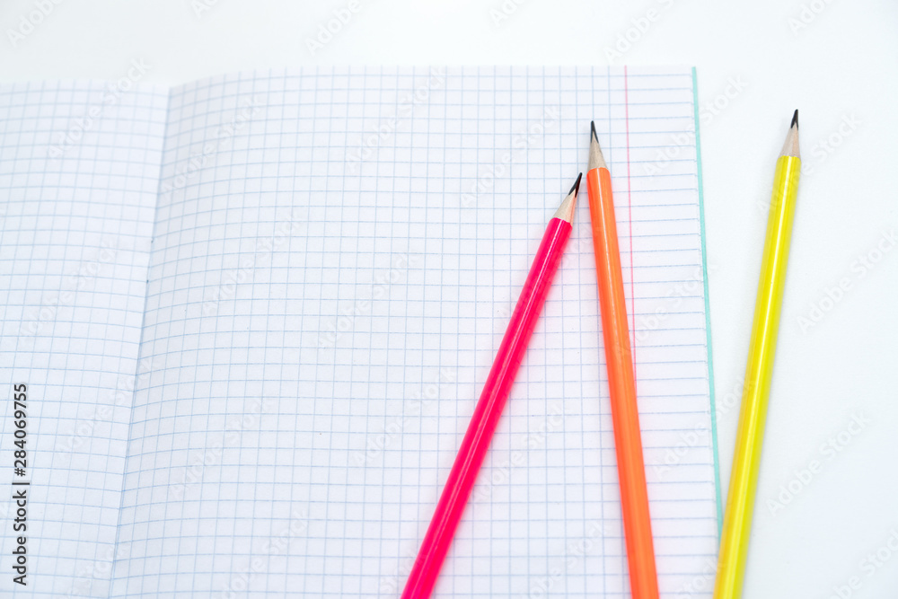 Blank notebook and pencils on white background. School supplies. White sketch book with colourful pencils. Note book and pencil Blank notebook and pencils on white background. School supplies. White sketch book with colourful pencils. Note book and pencil