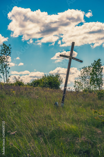christliches Kreuz auf einem grassigen Hügel