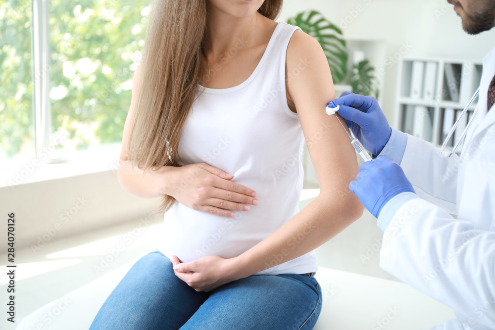 Doctor vaccinating pregnant woman in clinic Doctor vaccinating pregnant woman in clinic