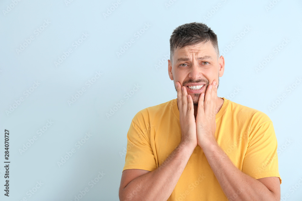 Man suffering from toothache against color background Man suffering from toothache against color background
