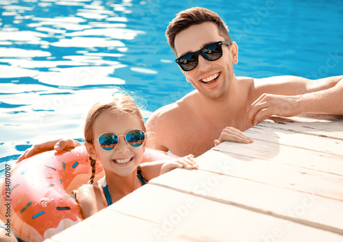 Father with little girl in swimming pool on summer day © Pixel-Shot