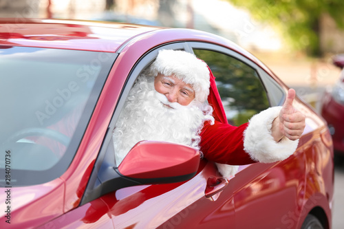 Santa Claus showing thumb-up gesture while driving car © Pixel-Shot