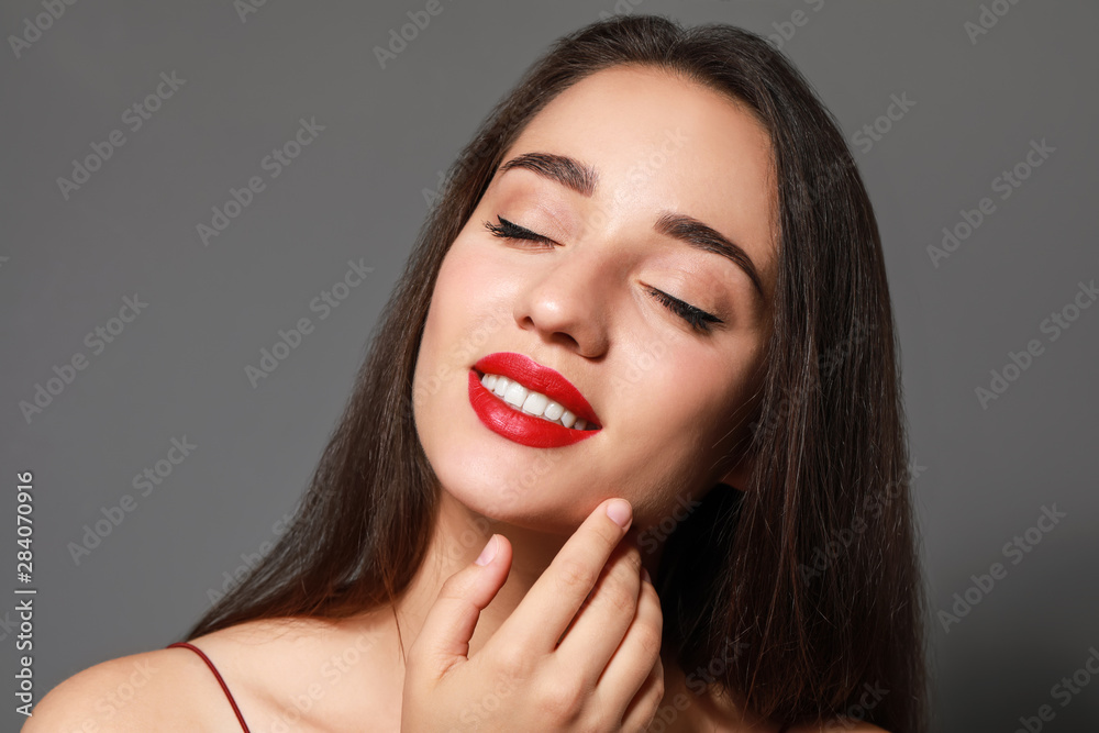 Beautiful young woman with bright lipstick on grey background Beautiful young woman with bright lipstick on grey background