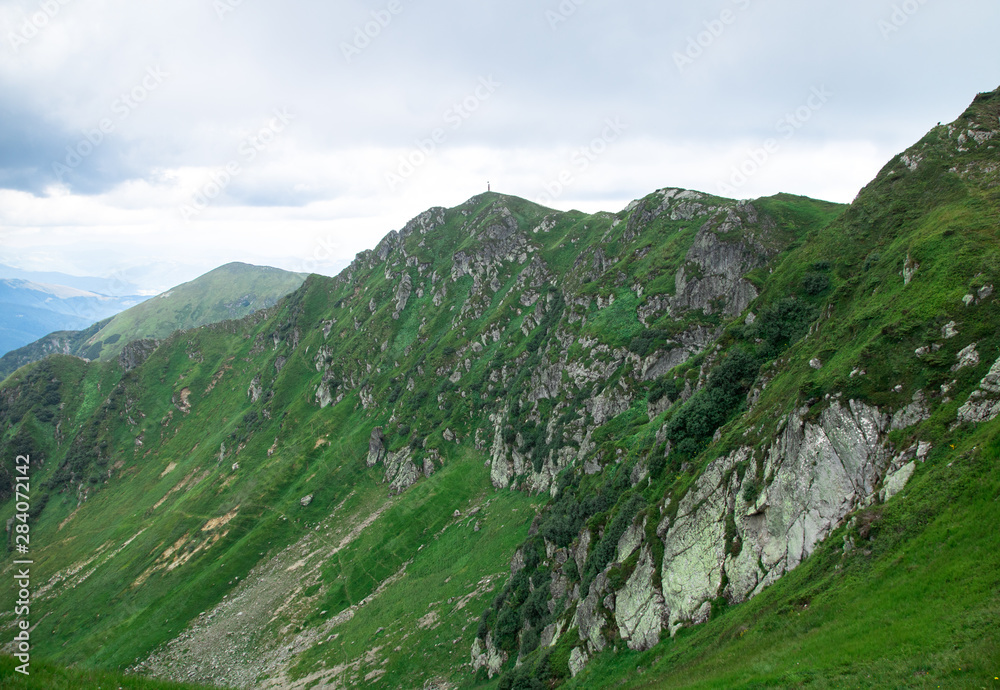 green mountain alps ridge, low gray clouds