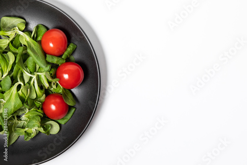 Fresh green salad with tomatoes on a white background  flat lay