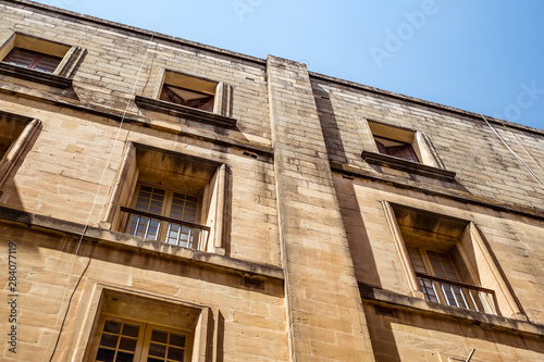 street with traditional balconies and old buildings in historical city Valletta Malta photo