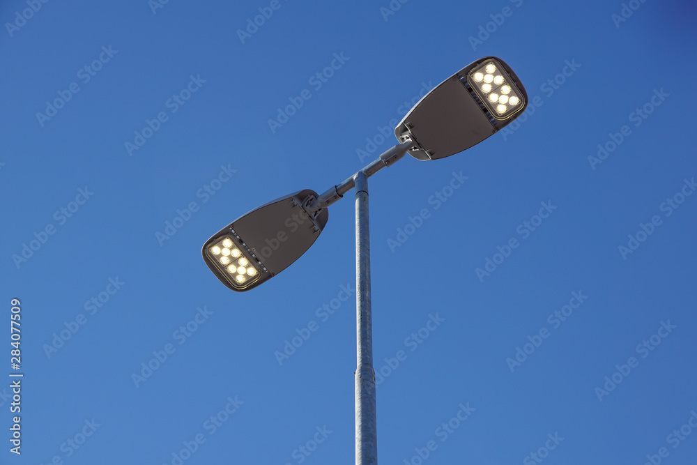 Three LED Street Lamps Affixed to an Iron Post Against a Deep Blue Sky Three LED Street Lamps Affixed to an Iron Post Against a Deep Blue Sky