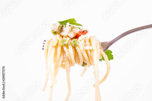 Spaghetti with cream sauce with smoked mackerel, peas ,bell pepper and some parsley eaten with a fork