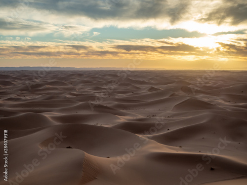 Sand dunes in Morocco  desert landscape  sand texture  tourist camp for night stay  panorama view of sunset over Sahara