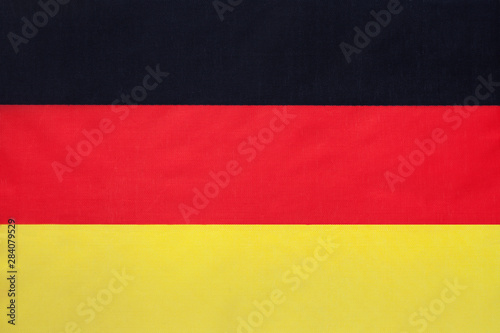 German national fabric flag  textile background. Symbol of international world european country.
