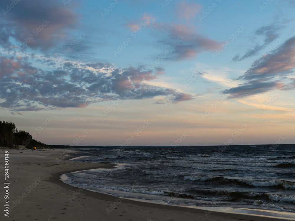 dramatic sunset, seashore, strong winds and blurred waves, beautiful and colorful skies, dusk