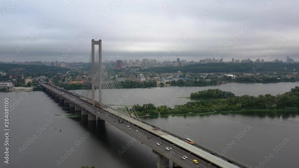 Aerial drone static shot of traffic moving along the Kiev South Bridge over the Dnieper River in Ukraine on an overcast day Aerial drone static shot of traffic moving along the Kiev South Bridge over the Dnieper River in Ukraine on an overcast day