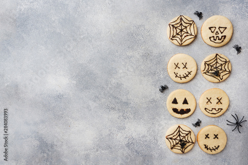 Homemade cookies for Halloween. Cookies with funny faces and spider webs. Copy space. © Elenglush