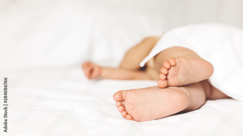 Baby sleeps on a white bed. Baby sleeps on a white bed.