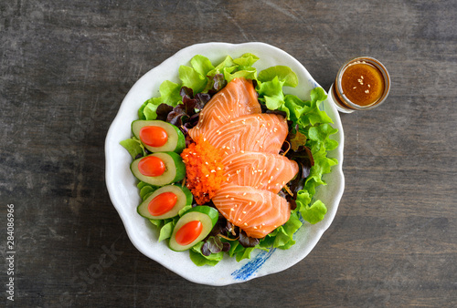 Raw Salmon sashimi with vegetable in ceramic bowl