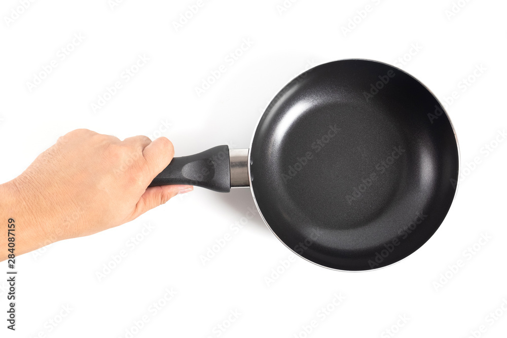 Hand holding a black frying pan. Isolated on white background Hand holding a black frying pan. Isolated on white background