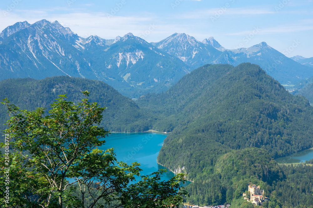 Beautiful summer day in bavarian Alps with a view to Alpsee lake and Neuschwanstein castle Germany from hiking trail