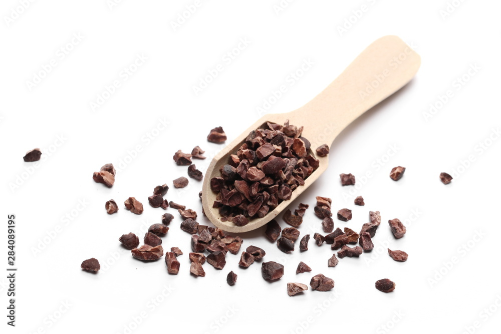 Chopped cocoa pile with wooden spoon isolated on white background Chopped cocoa pile with wooden spoon isolated on white background