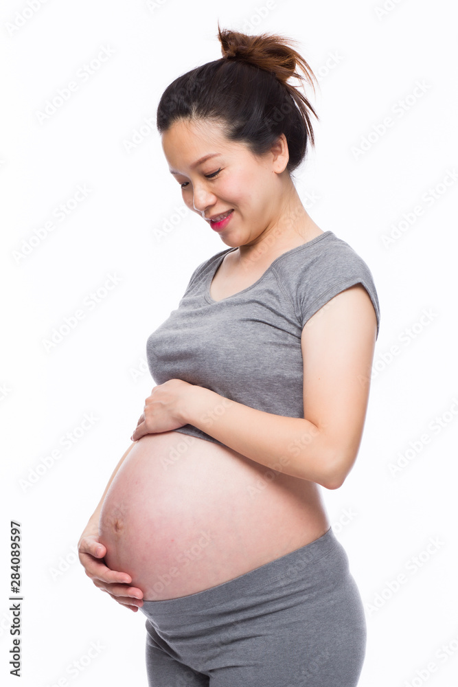 Happy asian pregnant woman smiling and touching her belly