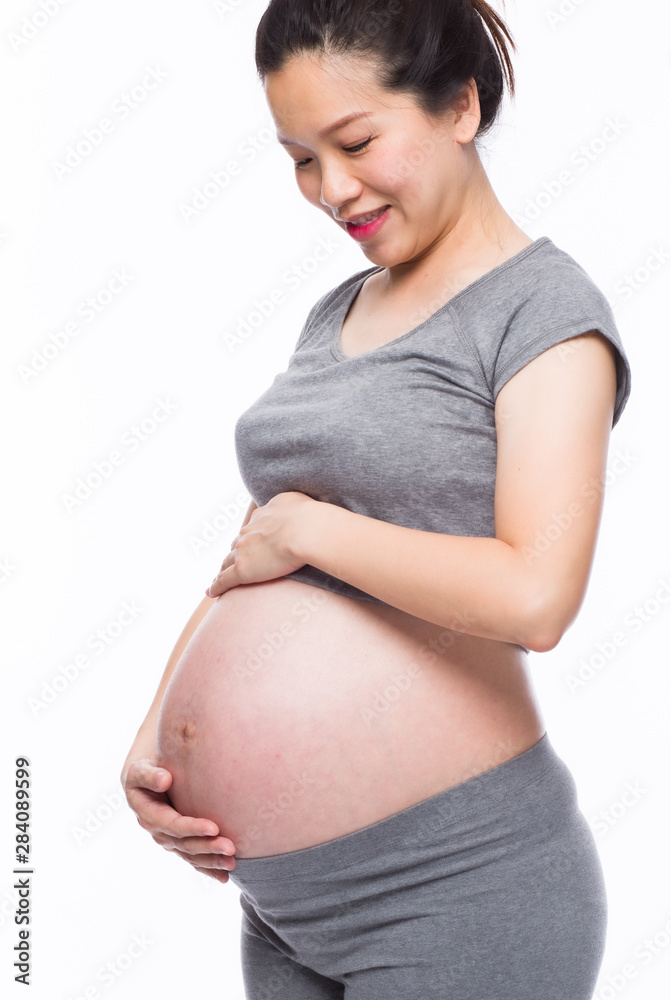 Happy asian pregnant woman smiling and touching her belly Happy asian pregnant woman smiling and touching her belly