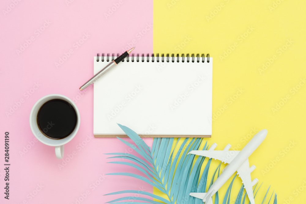Flat lay design of travel summer concept - Top view mockup of blank paper notebook, pen, pastel leaf, coffee and plane on pink yellow pastel color screen. Travel in summer on pastel color background. Flat lay design of travel summer concept - Top view mockup of blank paper notebook, pen, pastel leaf, coffee and plane on pink yellow pastel color screen. Travel in summer on pastel color background.